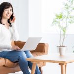 ソファでテレワークする女性